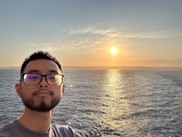 a man with glasses standing in the water